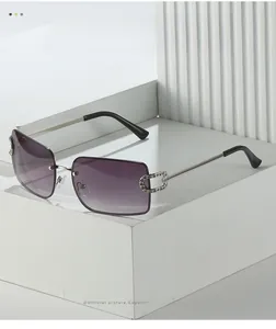 Close-up of rimless purple gradient sunglasses with silver crystal-studded metal hinges