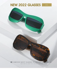 Close-up of retro oversized green and tortoiseshell sunglasses on white geometric display