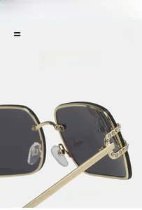 Detail of rimless square sunglasses with gold frame, geometric cutout and crystal rhinestones