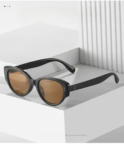Detail view of retro cat eye sunglasses with black frame and gold rivet accents