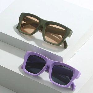 Retro oversized sunglasses with matte olive and purple frames on minimalist cubes