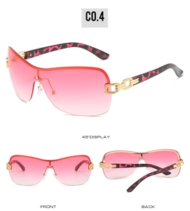 Detail view of pink gradient rimless Y2K sunglasses with gold chain temples and leopard print