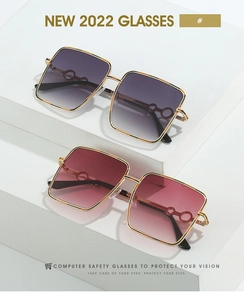 Detail of oversized square sunglasses with metal frames and gradient lenses on a white display