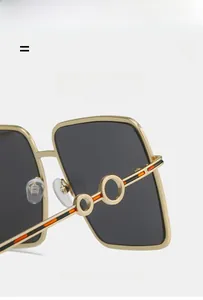 Detailed macro view of gold metal frames and striped temple hinges on square sunglasses