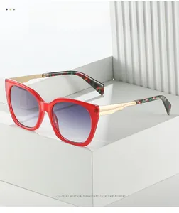 Detail of red square sunglasses featuring gold metal temples and purple gradient lenses