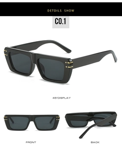 Detail of square flat-top sunglasses with thick black frame and golden metal accents