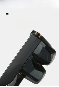 Detailed close-up of premium black flat top sunglasses hinge with gold metal accents