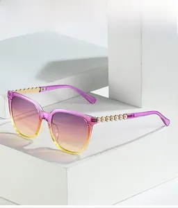 Detail of gradient purple lenses and gold metal temples with elegant pearl accents