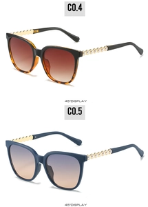 Detailed side view of cat-eye sunglasses featuring golden metal wavy legs and pearls