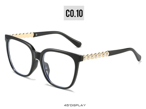 Detail of cat-eye sunglasses featuring gold wavy temples with elegant pearl inlay