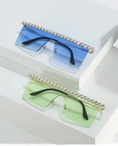 Détail de lunettes de soleil oversize sans monture avec strass et branches en métal
