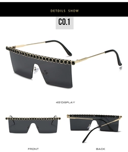 Vue détaillée de grandes lunettes de soleil sans monture avec strass noirs en haut