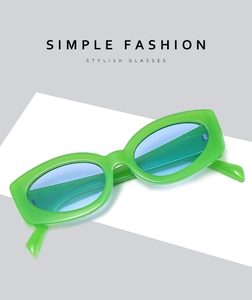 Detail of trendy small rectangle sunglasses with bright green frames and blue lenses