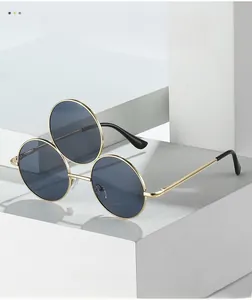 Close-up of novelty three-lens sunglasses with gold metal frames and dark lenses