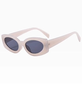Detail view of stylish cream thick frame oval sunglasses with dark lenses in cat eye style