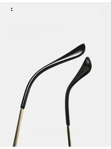 Detail of curved ergonomic sunglasses arms featuring gold metal joints and black temples