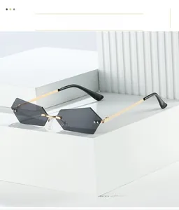 Close-up of rimless geometric sunglasses with grey gradient lenses and gold temples