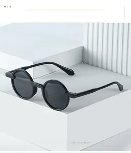 Close-up of vintage round sunglasses with black glossy frames on geometric background