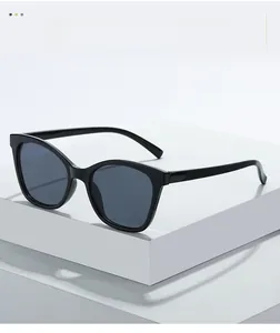 Gros plan sur la texture des lunettes œil-de-chat noires sur socle blanc épuré
