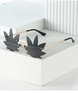 Detail of leaf-shaped rimless sunglasses with grey lenses and gold metal temples