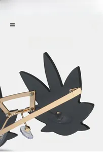 Detail of gold metal frame and leaf-shaped lens on these creative street style sunglasses