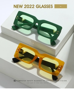 Détail de lunettes rectangulaires avec accents métalliques en V dorés et rivets rétro