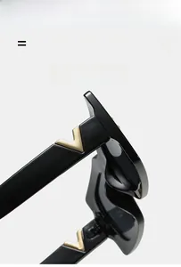 Détail de la branche de lunettes noires avec logo métallique doré en forme de V