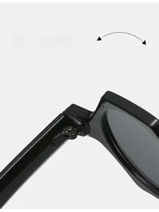 Détail de la charnière métallique robuste sur des lunettes de soleil noires géométriques