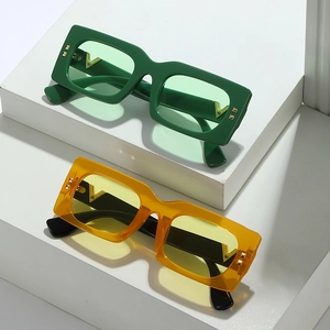 Lunettes de soleil vintage carrées avec rivets et détails en V sur des marches blanches
