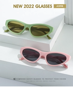 Detail view of stylish light green and pink cat-eye sunglasses on geometric white blocks