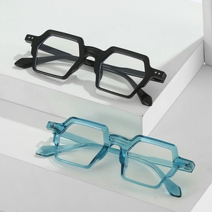Montures de lunettes géométriques surdimensionnées noires et bleu canard sur socle