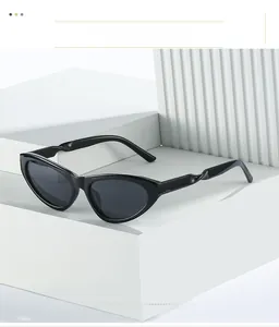 Detail of black cat eye sunglasses with unique twisted temples on a geometric pedestal