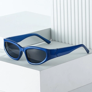 Lunettes de soleil œil de chat bleues style Y2K sur un socle géométrique minimaliste