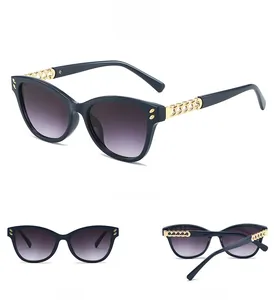 Detailed view of cat-eye sunglasses with gold chain temples and rivet accents