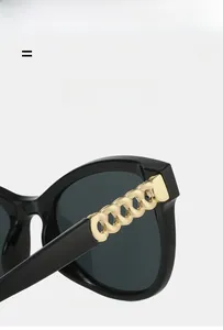 Detail view of cat eye sunglasses with golden chain link temple and rivets