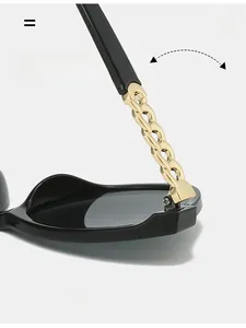 Close-up of golden cuban chain metal hinge on black oversized cat-eye sunglasses