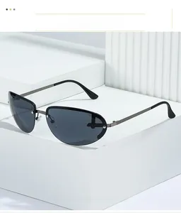 Detail of gunmetal pilot sunglasses with rimless lenses and metallic studs on a white podium