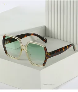 Detail of oversized hexagonal sunglasses featuring tortoiseshell frames and green lenses