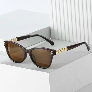 Chic cat-eye sunglasses with brown polarized lenses and gold chain link temples on white blocks