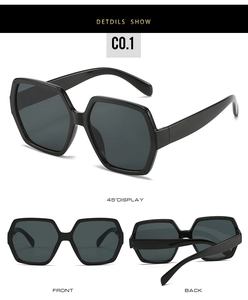 Three-dimensional view of black hexagonal oversized sunglasses with dark grey lenses