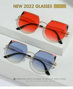 Close-up of golden cat-eye sunglasses with colorful geometric corners and gradient lenses