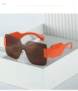 Détail de lunettes de soleil sans monture orange vif avec verres bruns et rivets