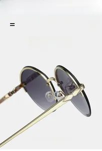 Detail view of gold metal frames and gray gradient lenses on these fashion oval sunglasses