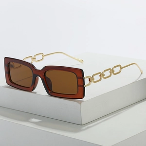 Square sunglasses with brown translucent frames and gold metal chain temples on a white stand