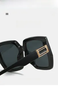 Detail of square sunglasses frame with decorative gold metal hinge on black temples