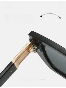 Detailed close-up of premium black square sunglasses frame with reinforced gold metal hinges