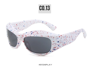Detail of white wrap-around sunglasses with red and blue paint splatter at 45-degree angle