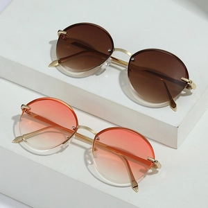 Oval gradient sunglasses with gold metal frame and rivet detail on white pedestals