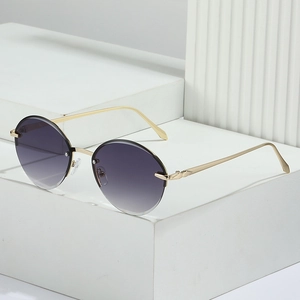 Oval rimless sunglasses with purple gradient lenses and gold metal frame on stone