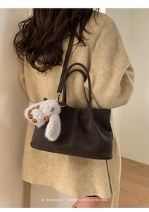 Minimalist dark brown suede tote bag featuring a cute grey plush bunny charm detail